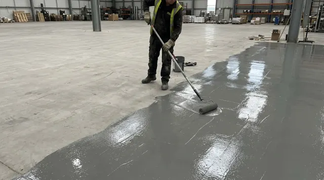 Rolling an epoxy primer onto a floor